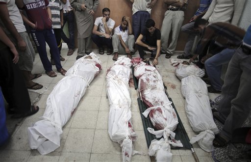 Palestinos lloran junto a los cadáveres de familiares muertos en un ataque de Israel contra una escuela de la ONU en el campo de refugiados de Jebaliya, en Beit Lahiya, en el norte de la Franja de Gaza, el miércoles, 30 de julio del 2014. (Foto AP/Khalil Hamra)