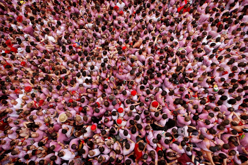 Juerguistas abarrotan la plaza del ayuntamiento durante el lanzamiento del cohete "El Chupinazo", que marca la inauguración oficial de las fiestas de San Fermín 2014 en Pamplona, España, el domingo 6 de julio de 2014. (Foto AP/Daniel Ochoa de Olza)