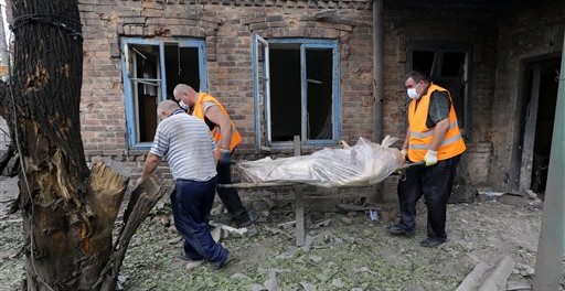 Rescatistas cargan el cuerpo de una mujer que murió durante un bombardeo en Donetsk, en el oriente de Ucrania el martes 5 de agosto de 2014. La ONU señaló que que la situación humanitaria en el oriente de Ucrania empeora. (Foto de AP/Sergei Grits)
