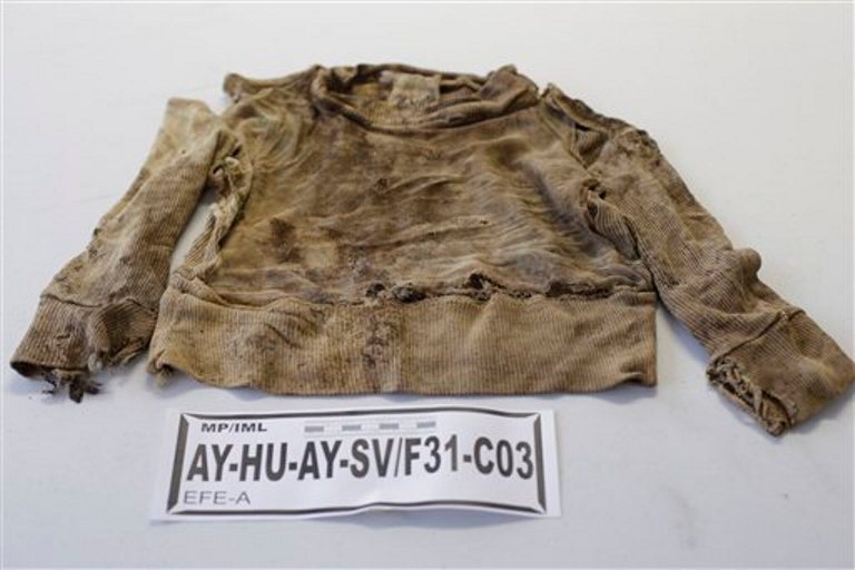 Una prenda de una persona asesinada por militares en la década del 80 y cuyos restos fueron exhumadas desde fosas clandestinas son exhibidas a la prensa en el ministerio público en Lima, Perú, el martes 9 de septiembre de 2014 .Forenses iniciaron la exhibición de ropa de 53 asesinados para que sus familiares puedan identificarlos por sus trajes que vestían la última vez que los vieron vivos.(AP Photo/Martin Mejia)