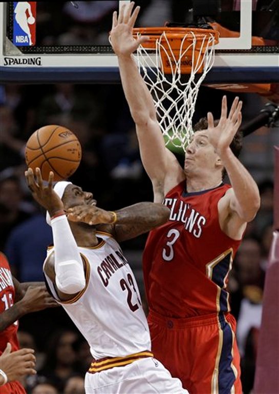 LeBron James, de los Cavaliers de Cleveland, recibe una falta del turco Omer Asik, de los Pelicans de New Orleans, en el partido del lunes 10 de noviembre de 2014 (AP Foto/Mark Duncan).