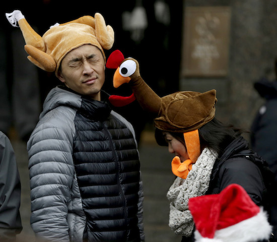 Tamari Hedani (derecha) toca a su novio Chris Chu, los dos de San Francisco, con su sombrero en forma de pavo antes del comienzo del Desfile de Macy's por el Día de Acción de Gracias. (Foto AP/Julio Cortez)