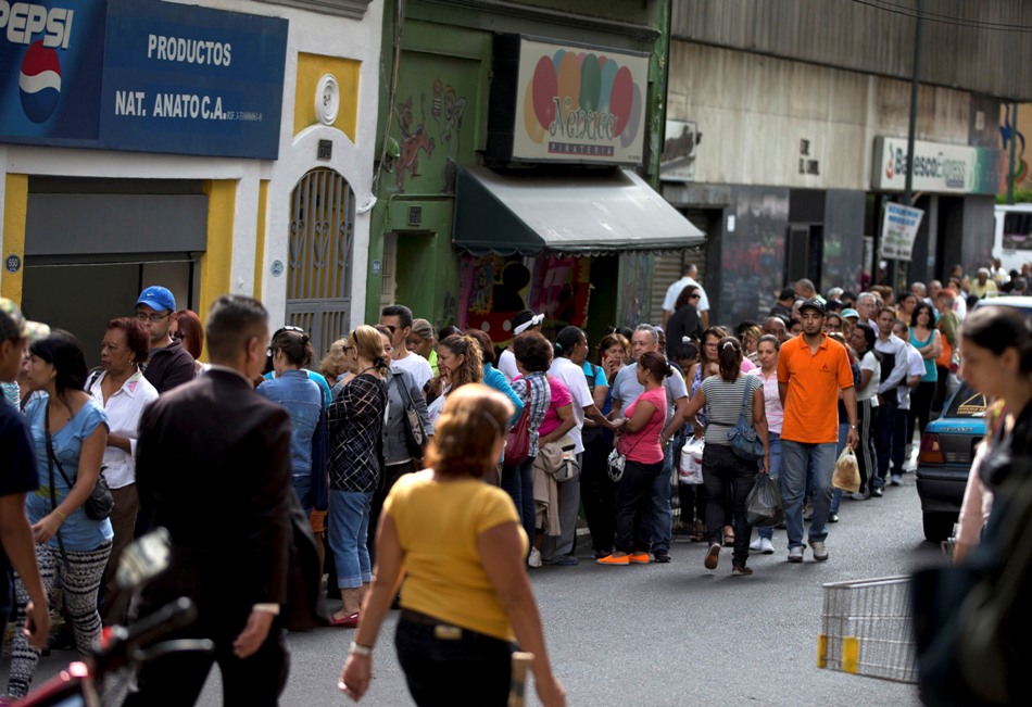 Clientes forman fila en un supermercado en el centro de Caracas, Venezuela, el jueves 8 de enero de 2015.  (AP Photo/Fernando Llano)
