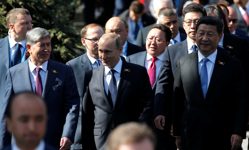De izquierda a derecha: El presidente de Kirguistán, Almazbek Atambayev; el presidente de Rusia, Vladimir Putin; el presidente de China, Xi Jinping caminan antes del inicio del desfile de la Victoria para celebrar el 70 aniversario de la derrota de los nazis en la II Guerra Mundial, en la Plaza Roja de Moscú, el 9 de mayo de 2015. (Foto AP/Alexander Zemlianichenko, Pool)