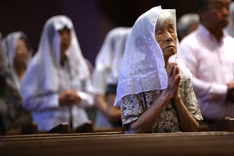 Católicos rezan durante una misa en recuerdo de las víctimas de la bomba atómica, el domingo 9 de agosto de 2015, en la catedral de Urakami, en la ciudad japonesa de Nagasaki, al cumplirse el 70 aniversario de la bomba lanzada por Estados Unidos que mató a más de 70.000 personas. (Foto AP/Eugene Hoshiko)