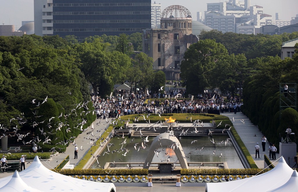 Palomas sobrevuelan un monumento de recuerdo a las víctimas de la bomba atómica en Peace Memorial Park de Hiroshima durante una ceremonia por el 70 aniversario del estallido de la bomba en la ciudad japonesa, el 6 de agosto de 2015. (Foto AP/Eugene Hoshiko)
