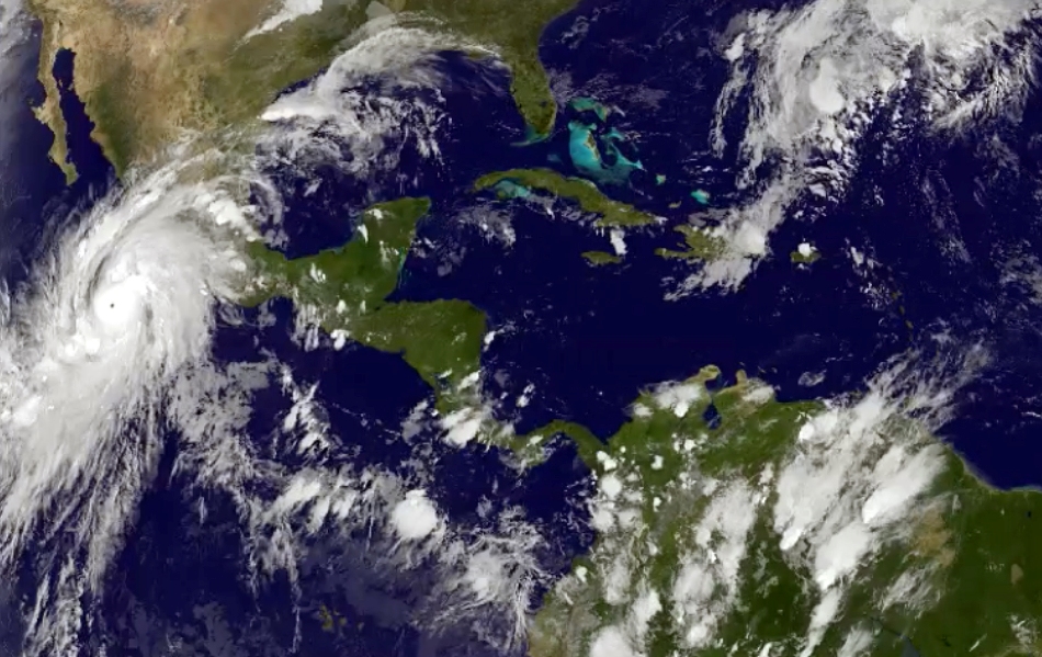 Esta imagen satelital tomada a las 8:45 p.m. hora del Este el jueves 22 de octubre de 2015, y dada a conocer por laOficina Nacional de Administración Oceánica y Atmosférica, muestra al huracán Patricia, a la izquierda, moviéndose hacia costas centrales del Pacífico mexicano. (NOAA via AP)
