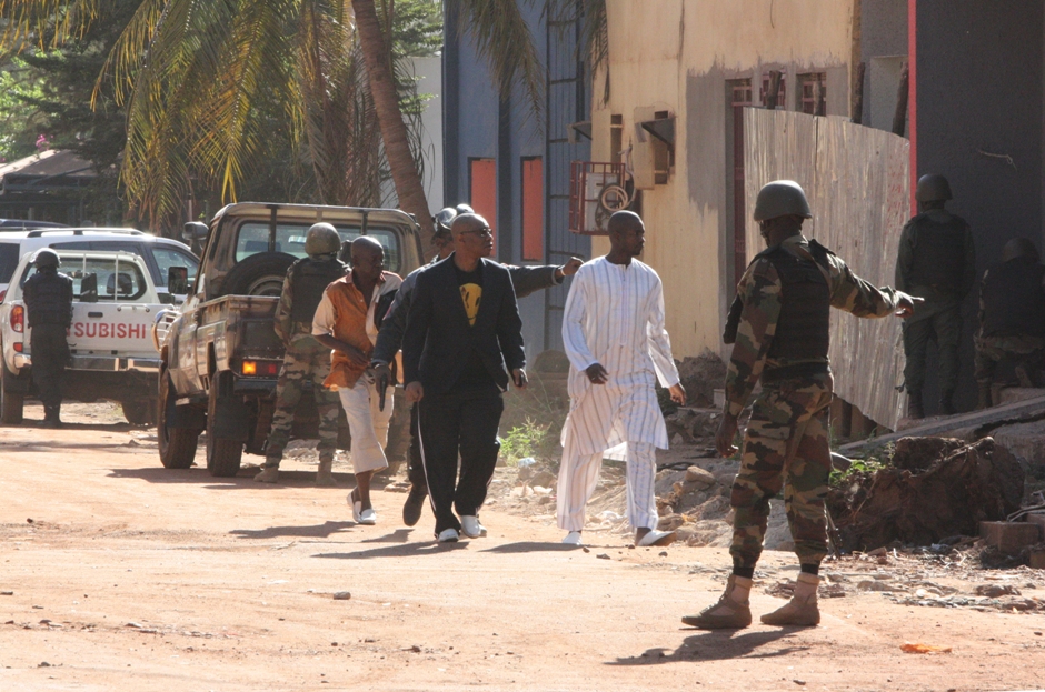 En la imagen, personal de seguridad escolta a personas que huyen del hotel Radisson Blu en Bamako, Mali, el viernes 20 de noviembre de 2015, donde varias personas lanzaron un ataque y tomaron rehenes. (AP Foto/Harouna Traore)