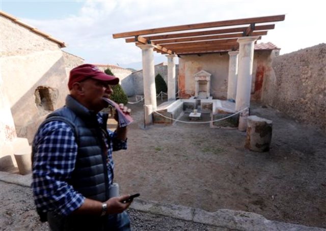 Un turista camina en la Casa dell'Efebo, uno de los seis sitios restaurados y abiertos al público en Pompeya, Italia, el jueves 24 de diciembre del 2015. (AP Foto/Riccardo De Luca)