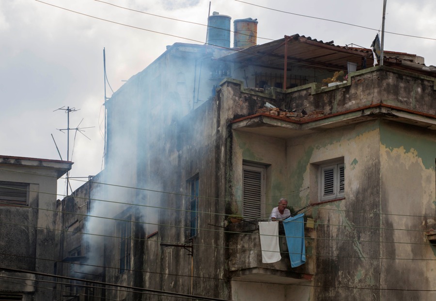 Un hombre espera en el balcón de su casa mientras es fumigada el 22 de febrero del 2016. El gobierno lanzó una campaña destinada a mantener a Cuba como el único país del continente sin el brote del virus del zika. El presidente Raúl Castro dijo que todavía no se ha registrado un solo caso de zika en Cuba. (AP Photo/Desmond Boylan)