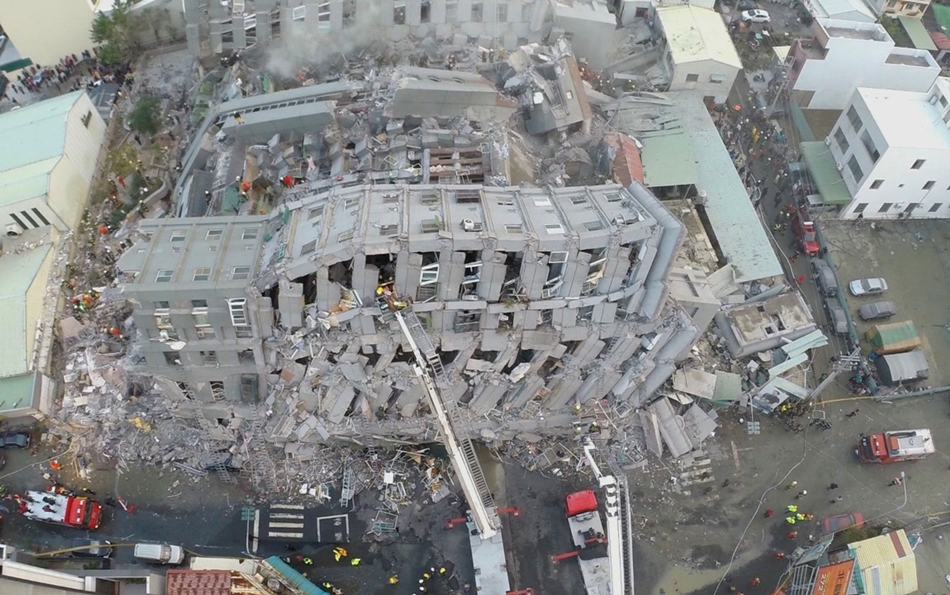 Socorristas buscan sobrevivientes en un edificio que se vino abajo tras un sismo en Tainan, Taiwán, el sábado 6 de febrero de 2016. La imagen fue tomada con una cámara instalada en un dron. Un fuerte sismo que tuvo poca profundidad sacudió el sur de Taiwán antes del amanecer del sábado. (AP Foto)