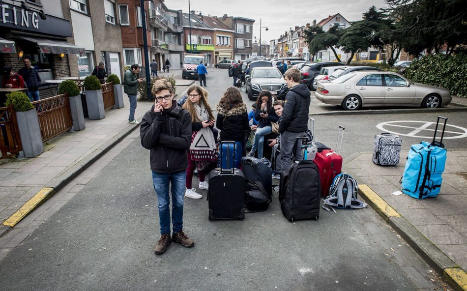 Varios pasajeros esperan junto a su equipaje cerca del aeropuerto internacional de Zaventem, cerca de Bruselas (Bélgica) hoy, 22 de marzo de 2016. Al menos 21 personas han muerto y otras 35 han resultado heridas en las explosiones que afectaron hoy al aeropuerto de Zaventem, en Bruselas, y la estación de metro de Maalbeek, en el centro de la capital europea. EFE/Jonas Roosens