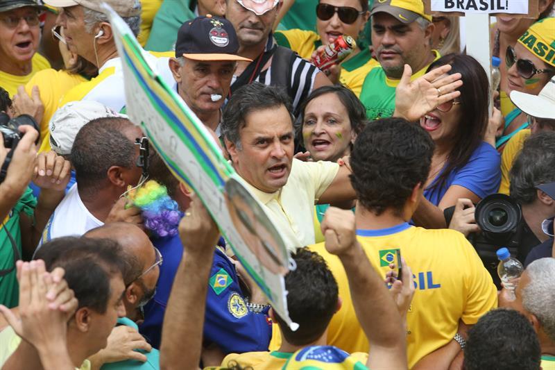 El senador brasileño Aécio Neves (c) participa junto a cientos de manifestantes que se reúnen en la Plaza de la Libertad hoy, domingo 13 de marzo de 2016, para pedir la destitución de la presidenta brasileña Dilma Rousseff en Belo Horizonte, Minas Gerais (Brasil). 