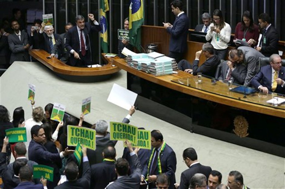 El Fiscal General de Brasil, José Eduardo Cardozo, arriba a la izquierda, defiende a la presidenta de Brasil, Dilma Rousseff, en la Cámara de Diputados, mientras que líderes de oposición sostienen pancartas que en portugués dicen "Adiós querida" y "Juicio Político Ya" en Brasilia, Brasil, el viernes 15 de abril de 2016. (AP Foto/Eraldo Peres)