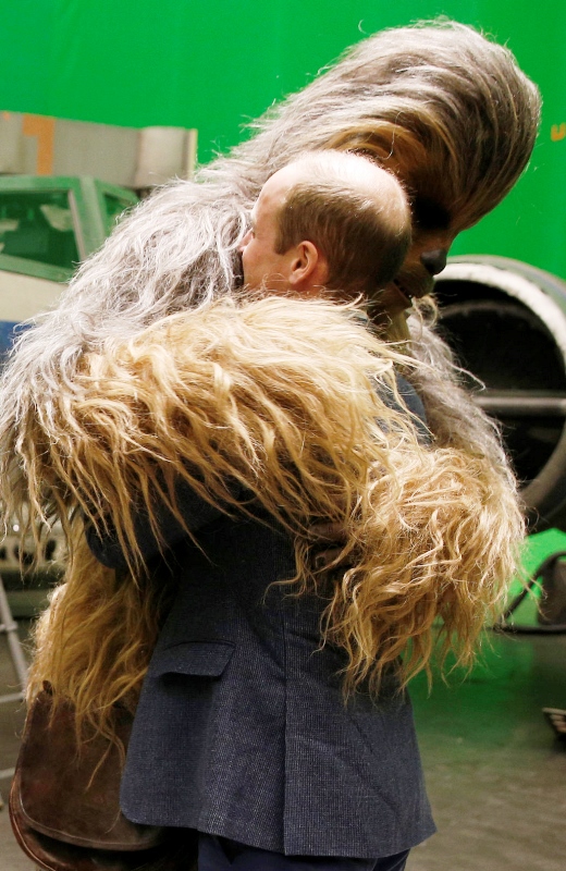 El príncipe Guillermo de Gran Bretaña recibe un abrazo del personaje Chewbacca durante una visita al plató de Star Wars en los estudios Pinewood, el martes 19 de abril del 2016 en Iver Heath, en el oeste de Londres. (Adrian Dennis/Pool vía AP)