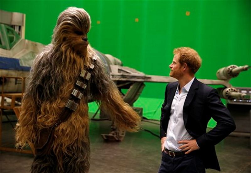 El príncipe Enrique de Gran Bretaña conoce al personaje de Chewbacca durante una visita al plató de Star Wars en los estudios Pinewood, el martes 19 de abril del 2016 en Iver Heath, en el oeste de Londres. (Adrian Dennis/Pool vía AP)