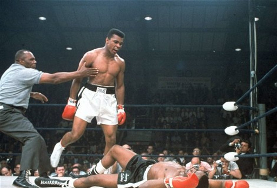 ARCHIVO - En esta imagen de archivo del 25 de mayo de 1965, el campeón de peso completo Muhammad Ali es retenido por el árbitro Joe Walcott, a la izquierda, después de que Ali noqueara a su rival Sonny Liston en el primer asalto de su combate por el título en Lewiston, Maine. Ali, el indómito campeón peso completo cuyos demoledores golpes y avasalladora personalidad transformaron el deporte y le hicieron una superestrella mundial, ha fallecido, informó su familia. Tenía 74 años. (AP Foto/Archivo)