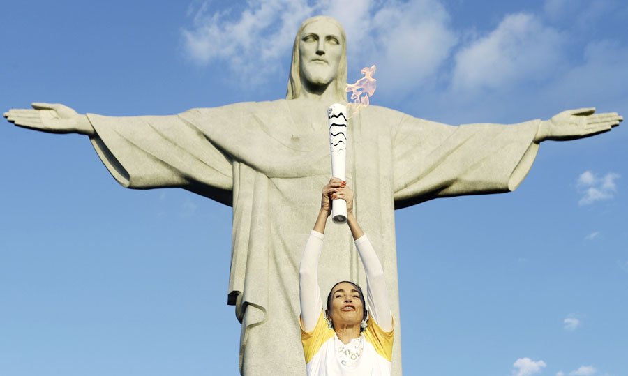 La exjugadora de voleibol brasileña Isabel Barroso Salgado lleva la antorcha olímpica hoy, viernes 05 de agosto de 2016, en el Cristo Redentor, en Río de Janeiro (Brasil). La inauguración de los Juegos Olímpicos se realizará hoy a las 20:00, hora local, en el Estadio Maracaná de Río. EFE / Fernando Maia