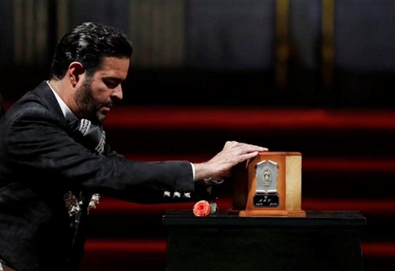 El cantante Pablo Montero toca la urna con las cenizas de Juan Gabriel para decir adiós al superastro de la música mexicana, el lunes 5 de septiembre del 2016 en el Palacio de Bellas Artes, en la Ciudad de México. (AP Foto/Rebecca Blackwell)