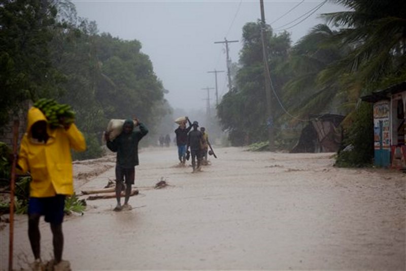 Varios residentes caminan en calles inundadas mientras regresan a sus casas en Leogane, Haití, el martes 4 de octubre de 2016, tras el paso del huracán Matthew. (AP Foto/Dieu Nalio Chery)