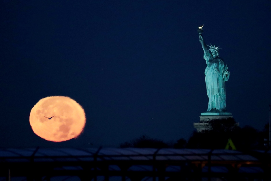La Luna detrás de la Estatua de la Libertad, en las primeras horas del lunes 14 de noviembre de 2016, en Nueva York. (AP Foto/Julio Cortez)