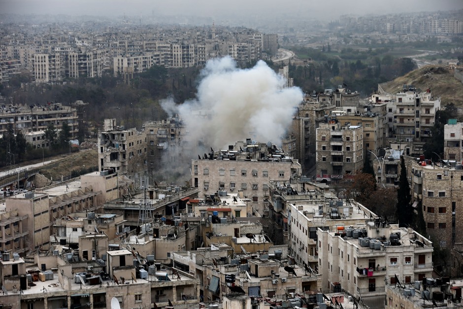 Una columna de humo se eleva después de que combatientes rebeldes lanzaran un mortero contra un barrio residencial en el oeste de Alepo, Siria, el lunes 5 de diciembre de 2016. (AP Foto/Hassan Ammar)