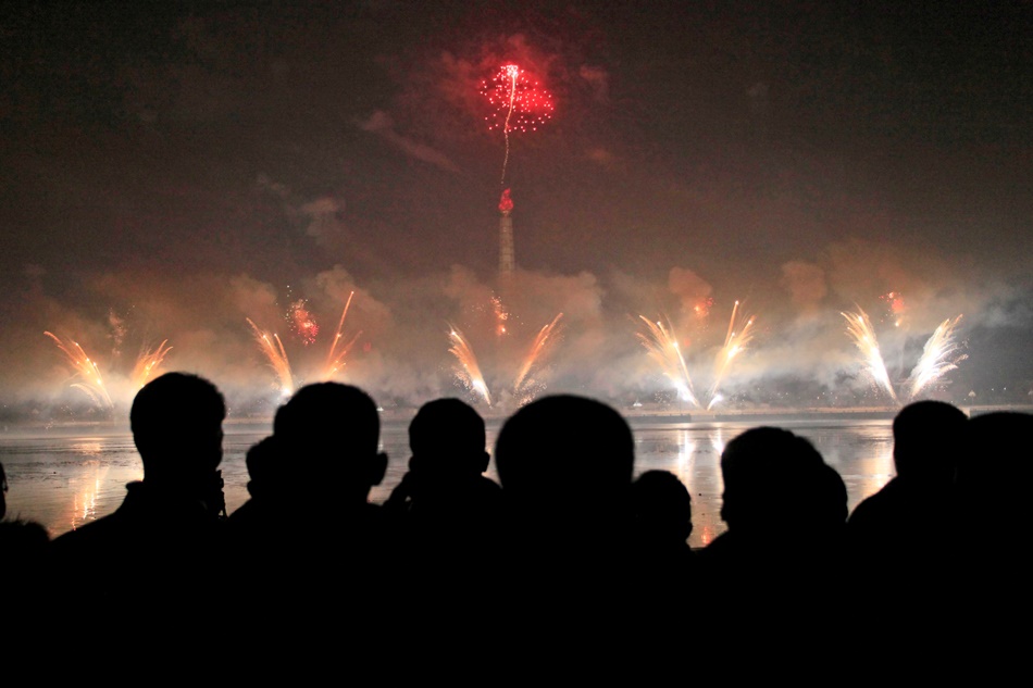 Norcoreanos observan una exhibición de fuegos artificiales en la Plaza Kim Il Sung de Pyongyang, Corea del Norte, el 1 de enero de 2017. (AP Foto/Kim Kwang Hyon)