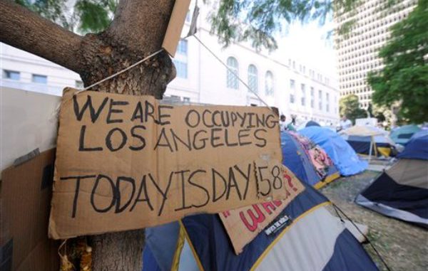 Los manifestantes de Ocupemos Los Angeles acampan frente al Ayuntamiento de Los Angeles, California, el domingo 27 de noviembre del 2011. El plazo se cumplió a la medianoche para que cientos de manifestantes del movimiento Ocupemos Los Angeles desalojen su campamento establecido sobre el césped del Ayuntamiento, pero por el contrario, éstos continuaban una "fiesta de bloqueo de desalojo". (Foto AP/Phil McCarten)