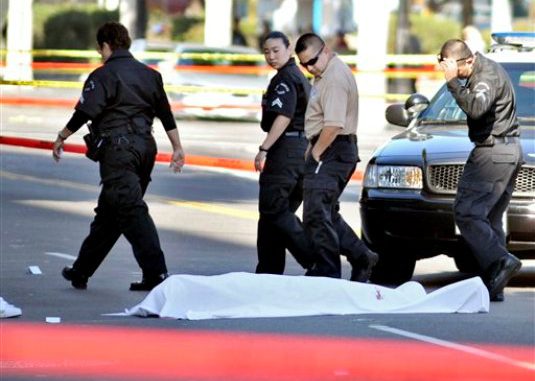 Policías de Los Angeles pasan junto a un cadáver tras el ataque con arma de fuego de un hombre de 26 años, sin un objetivo aparente, contra conductores el viernes 9 de diciembre de 2011 en Los Angeles. El ejecutivo musical John Atterberry murió el lunes 12 de diciembre de 2011 tras sufrir el ataque del hombre, informaron autoridades del hospital en el que se encontraba Atterberry. (Foto AP/ Josh Edelson)
