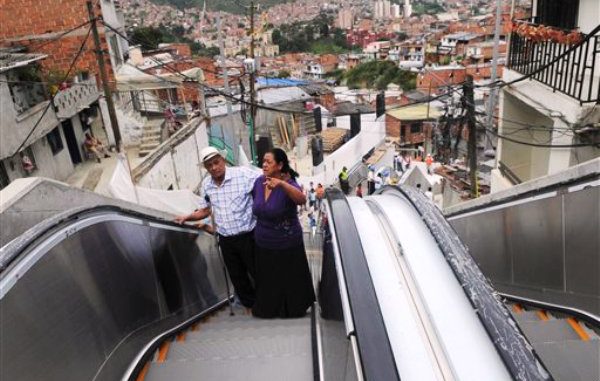 Luis Hernesto Holguin, izquierda, y su hermanar Resfa, usan una escalera mecánia al aire libre recién inaugurada en el suburbio Comuna 13 como parte de un plan de mejoramiento urbano para los habitantes de Medellín, Colombia, el lunes 26 de diciembre de 2011. (AP Photo/Luis Benavides)