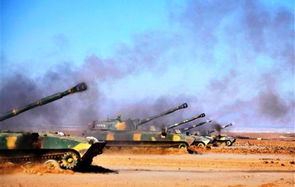 Tanques del ejército sirio abren fuego durante maniobras efectuadas en una ubicación no precisada en Siria, de acuerdo con esta fotografía que facilitó el domingo 4 de diciembre la agencia noticiosa oficial del país. La prensa estatal dijo que las maniobras se efectuaron el domingo e incluyeron disparo de misiles y operaciones coordinadas entre la fuerza aérea y efectivos en tierra "similares a una batalla de verdad". (AP foto/SANA)