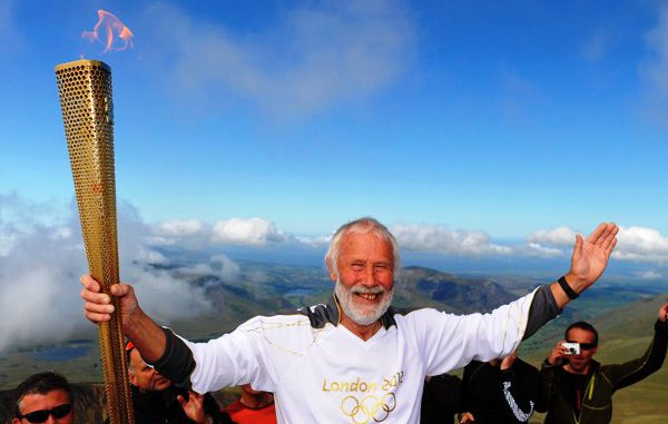 British mountaineer Chris Bonnington holds the Olympic flame on top of Snowdon, the highest peak in Wales, in Snowdonia National Park, Wales May 29, 2012. The flame was carried through Wales on day 11 of the Torch Relay, as part of the London 2012 Olympic Games. REUTERS/LOCOG/Handout (BRITAIN - Tags: SPORT OLYMPICS SOCIETY) NO SALES. NO ARCHIVES. FOR EDITORIAL USE ONLY. NOT FOR SALE FOR MARKETING OR ADVERTISING CAMPAIGNS. THIS IMAGE HAS BEEN SUPPLIED BY A THIRD PARTY. IT IS DISTRIBUTED, EXACTLY AS RECEIVED BY REUTERS, AS A SERVICE TO CLIENTS