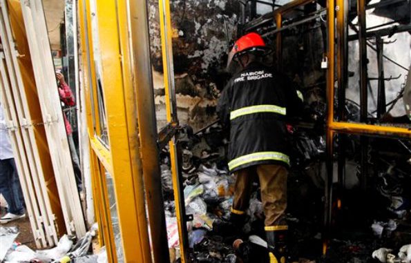 Un bombero keniano observa los escombros en una tienda tras una explosión que se registró en un edificio lleno de pequeños locales comerciales en el centro de Nairobi, la capital de Kenia, el lunes 28 de mayo de 2012. El primer ministro del país indicó que el incidente fue deliberado y una mujer acusó a un "hombre con barba" de haber dejado una bolsa en el lugar poco antes de la explosión. (Foto AP/Sayyid Azim)