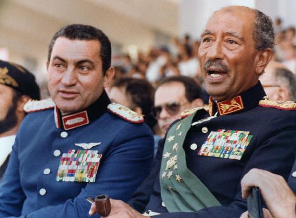 Egyptian vice President, Gen. Hosni Mubarak (L) and late President Anwar Sadat (R), both dressed in military honour uniforms, attend a military parade, 06 October 1981, in Cairo, commemorating Victory Day. Moments after, a group of military Islamist fundamentalists with allegiance to the Al-Jihad group killed Sadat in a shooting spree. Following Sadat’s assassination Mubarak was sworn in as Egypt?s fourth president, a position of power he has since retained, being re-elected five times. AFP PHOTO/- (Photo credit should read AFP PHOTO/AFP/Getty Images)