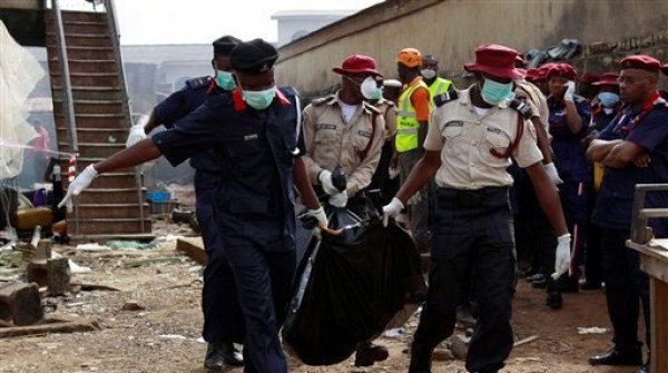 Trabajadores de rescate cargan cuerpos en el sitio del accidente aéreo en Lagos, Nigeria, el lunes 4 de junio de 2012. Un avión de pasajeros con más de 150 personas a bordo se estrelló en una zona residencial en lagos el domingo. (Foto AP/Sunday Alamba)
