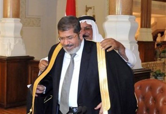 En esta fotografía proporcionada por la Presidencia de Egipto, el mandatario electo Mohammed Morsi recibe la toga tradicional durante una reunión con representantes de partidos políticos, el jueves 28 de junio de 2012, en El Cairo, Egipto. (Foto AP/Egyptian Presidency)
