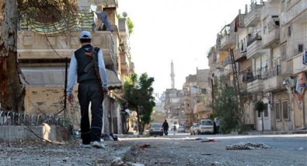 En imagen del martes 15 de mayo de 2012, un rebelde sirio camina en el vecindario Khaldiyeh de la provincia de Homs, en el centro de Siria. Naciones Unidas informó el miércoles 16 de mayo que espera evacuar en las próximas horas a un grupo de observadores internacionales que el martes se vio en medio de una zona bajo fuego en el norte del país y que al parecer quedó varado en el área durante toda la noche. (Foto AP/Fadi Zaidan)