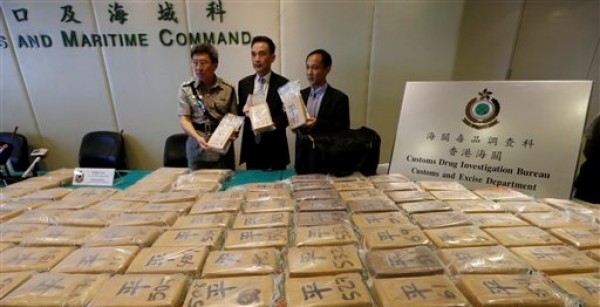 Funcionarios aduaneros presentan los paquetes de cocaína en las instalaciones del Departamento de Aduanas de Hong Kong el viernes 6 de julio del 2012. Las autoridades realizaron la mayor redada antidrogas que se haya registrado en la ciudad, con la incautación de 649 kilogramos (1.430 libras) de cocaína en un contenedor procedente de Ecuador, por un valor de 98 millones de dólares en su venta callejera. (Foto AP/Kin Cheung)
