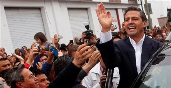 El candidato presidencial por el opositor Partido Revolucionario Institucional (PRI), Enrique Peña Nieto, adelante en las encuestas, saluda a partidarios luego de emitir su voto en Atlacomulco durante las elecciones generales mexicanas, el 1 de julio de 2012. (AP Foto/Esteban Felix)