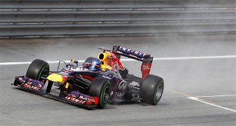 El piloto alemán Sebastian Vettel, del equipo Red Bull, toma una curva bajo la lluvia durante la sesión clasificatoria en la pista de Sepang, Malasia, el sábado 23 de marzo de 2013. Vettel obtuvo el primer lugar de la largada para el Gran Premio de Malasia que se disputa el domingo en Sepang. (AP Foto/Lai Seng Sin)