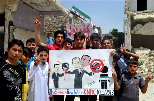 Imagen de periodistas ciudadanos provista por la red noticiosa Edlib y acreditada con base en su contenido y otro reporteo de The Associated Press, en la que manifestantes que se oponen al gobierno sirio sostienen un póster que dibuja al presidente Bashar Assad (izquierda), al canciller ruso Sergei Lavrov (al centro) y al presidente de Estados Unidos Barack Obama (derecha), durante una protesta en Kafr Nabil, en el norte de Siria, el viernes 10 de mayo de 2013. (Foto AP/Red noticiosa Edlib)