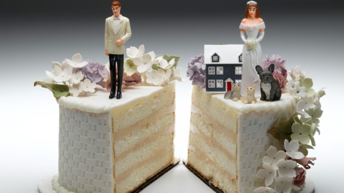 Bride and groom figurines standing on two separated slices of wedding cake