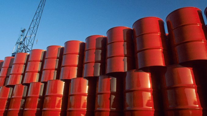 Red metal barrels against blue sky.