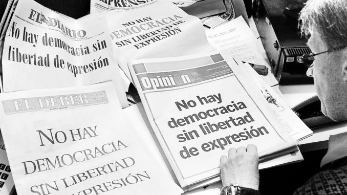 A man looks at the front pages of independent newspapers, all reading