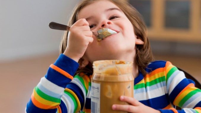 Mixed race boy eating peanut butter