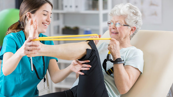 Physical therapist helps patient use resistance band