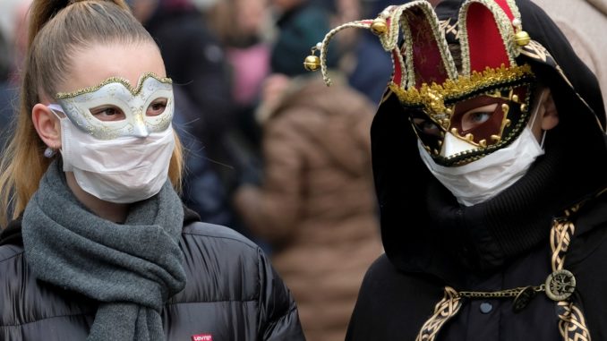Masked carnival revellers wear protective face masks at Venice Carnival