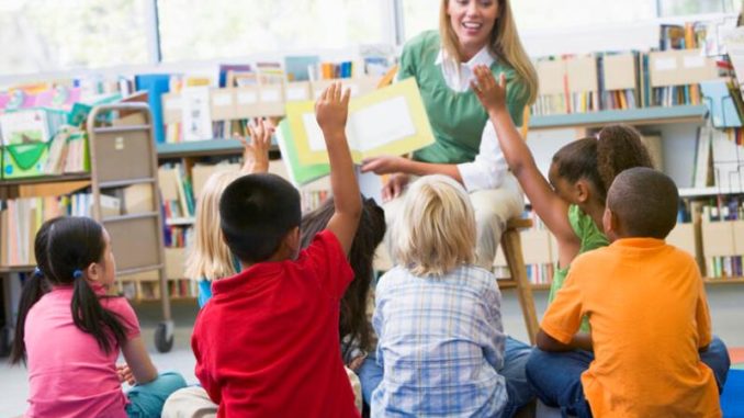 Kindergarten teacher reading to children