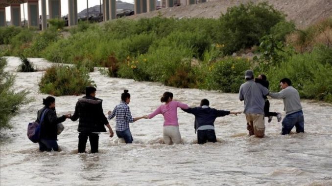 migrantes frontera de la mano