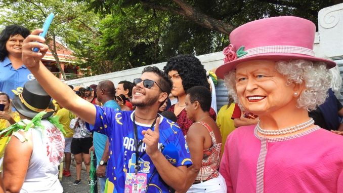 AME6275. OLINDA (BRASIL), 20/02/2023.- Personas se tomas fotos con muñecos gigantes que retratan a grandes personalidades nacionales e internacionales durante un desfile en el marco del Carnaval de Brasil en Olinda, Pernambuco, nordeste de Brasil (Brasil). os fallecidos 'O Rei' Pelé y la reina Isabel II 'revivieron' este lunes en el tradicional desfile de muñecos gigantes de la ciudad de Olinda, una de las citas más emblemáticas del Carnaval de Brasil y que este año evitó la política. El exdelantero brasileño y la monarca británica, fallecidos el 29 de diciembre y el 8 de septiembre de 2022, respectivamente, integraron el centenar de enormes figuras que invadieron el centro histórico de esta turística ciudad de la zona metropolitana de Recife. EFE/ Ney Douglas